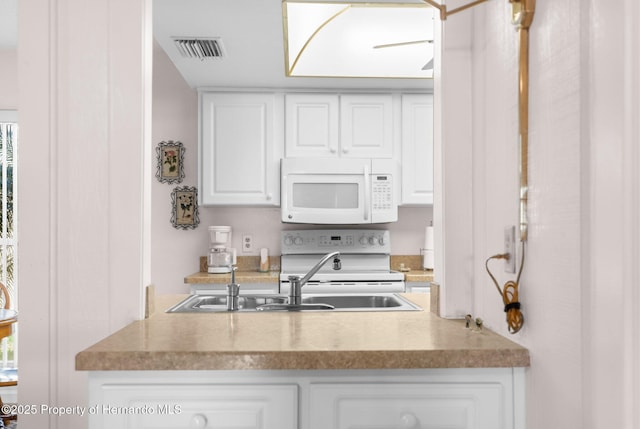 kitchen with white appliances, sink, ceiling fan, and white cabinetry