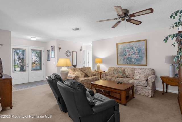 carpeted living room featuring a textured ceiling and ceiling fan