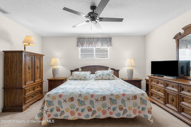 bedroom featuring light carpet, ceiling fan, and a textured ceiling