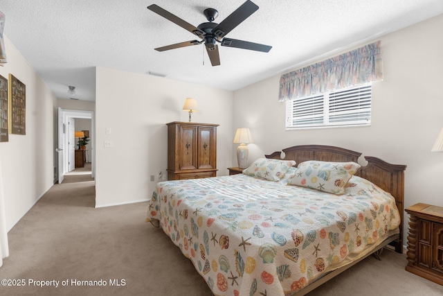 bedroom with light colored carpet, ceiling fan, and a textured ceiling