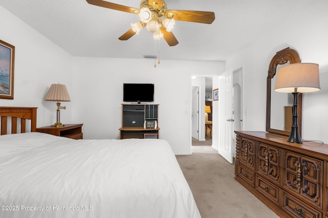 carpeted bedroom with ceiling fan and a textured ceiling