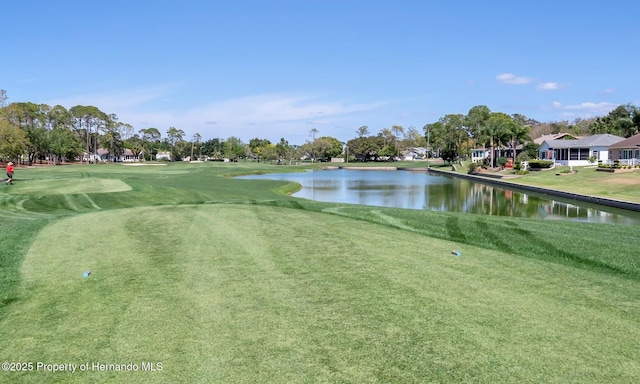 view of property's community with a water view and a lawn