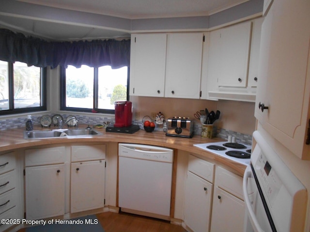 kitchen featuring sink, white appliances, white cabinetry, and a healthy amount of sunlight