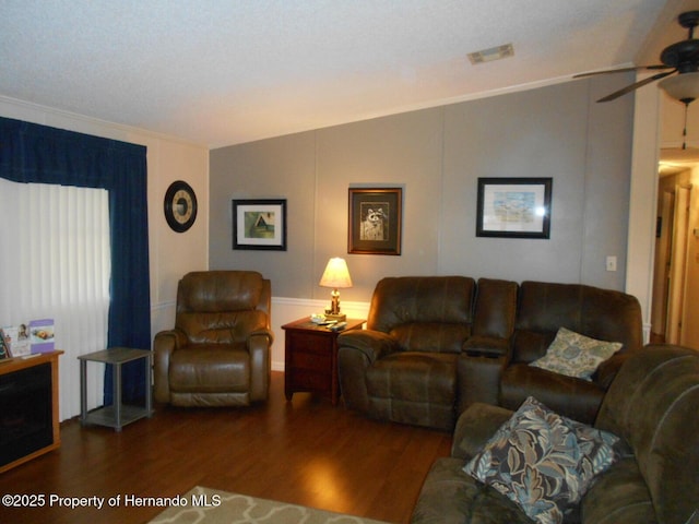 living room featuring ceiling fan, dark wood-type flooring, and crown molding