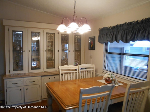 dining area featuring ornamental molding, vaulted ceiling, and a chandelier