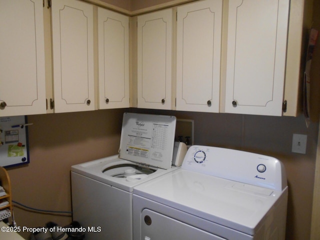 clothes washing area with cabinets and independent washer and dryer