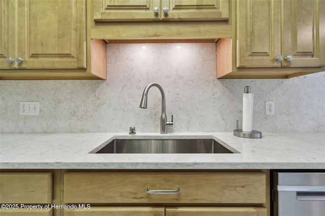 kitchen with sink, light stone counters, and decorative backsplash