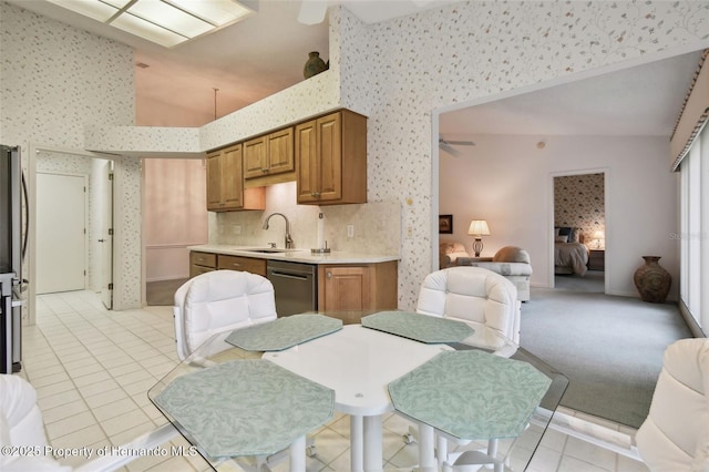 kitchen featuring light carpet, stainless steel appliances, ceiling fan, decorative backsplash, and sink