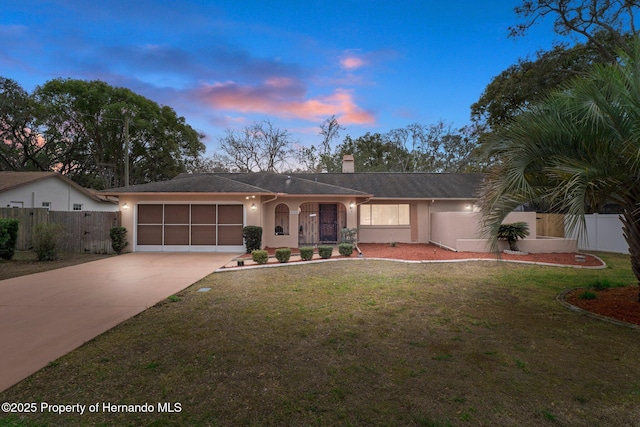 ranch-style house with a yard and a garage