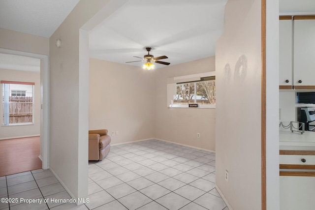 tiled spare room featuring ceiling fan