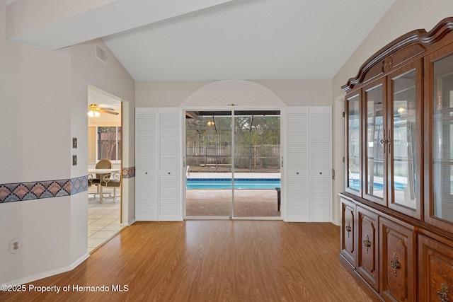 interior space featuring light hardwood / wood-style floors and vaulted ceiling