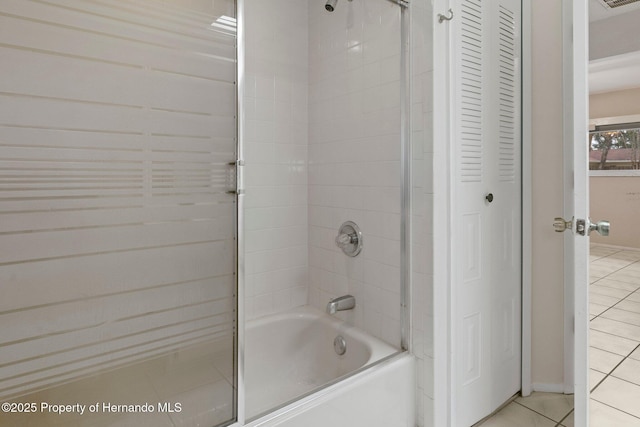 bathroom with tiled shower / bath and tile patterned flooring