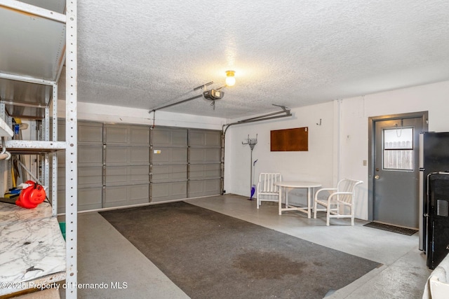 garage with black refrigerator and a garage door opener