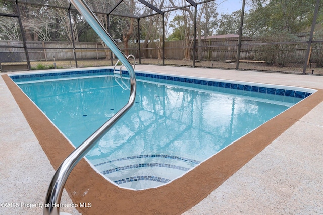 view of swimming pool featuring glass enclosure