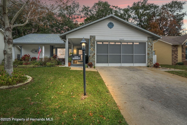 view of front of house with a garage, covered porch, and a lawn