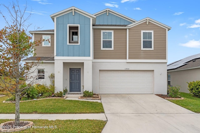 view of front of home with a front yard and a garage