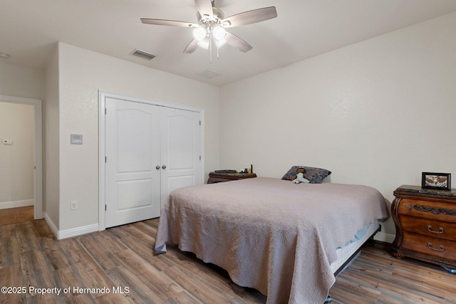 bedroom with ceiling fan, hardwood / wood-style floors, and a closet