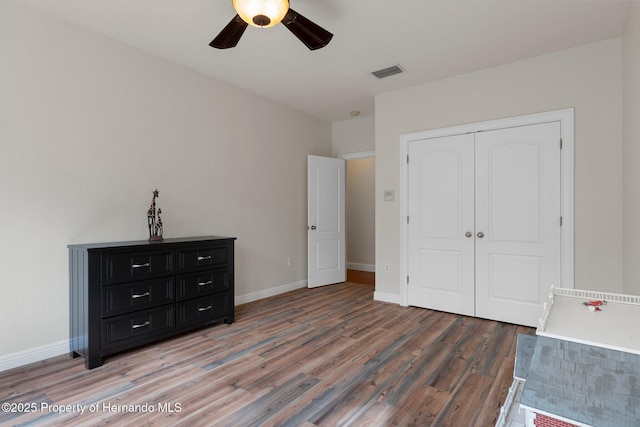 unfurnished bedroom with a closet, ceiling fan, and dark hardwood / wood-style flooring