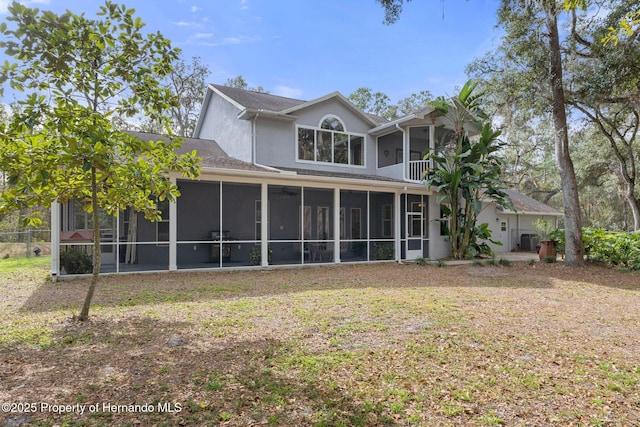 rear view of house featuring central air condition unit and a sunroom