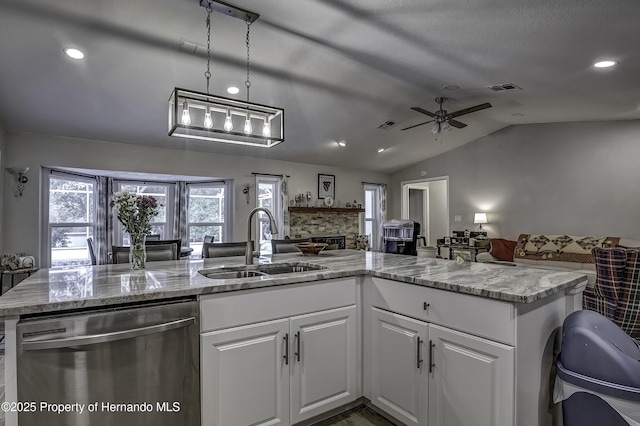 kitchen with dishwasher, vaulted ceiling, hanging light fixtures, white cabinets, and sink