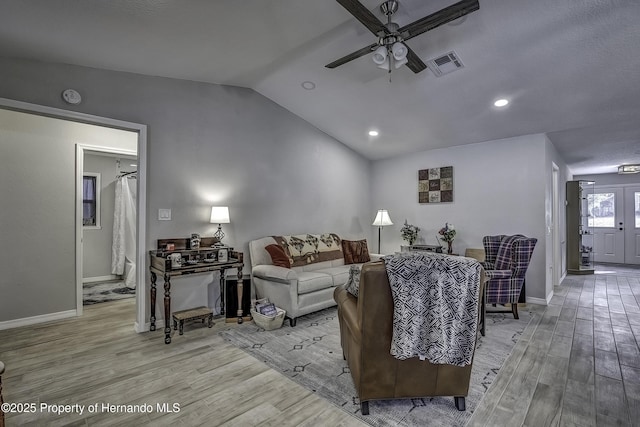 living room featuring ceiling fan, light wood-type flooring, french doors, and lofted ceiling