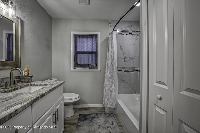 full bathroom featuring a textured ceiling, hardwood / wood-style flooring, toilet, shower / bath combo with shower curtain, and vanity