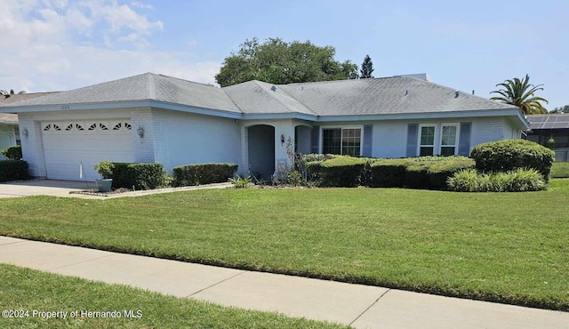 ranch-style home featuring a front lawn and a garage