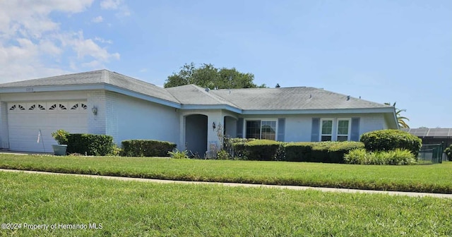 ranch-style house with a front yard and a garage