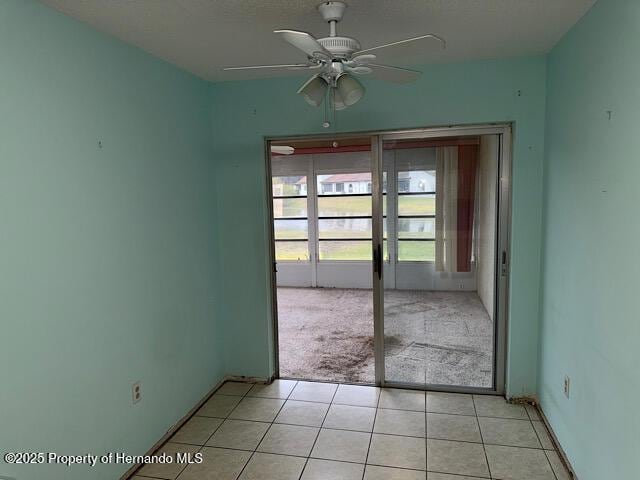 unfurnished room with ceiling fan and light tile patterned flooring