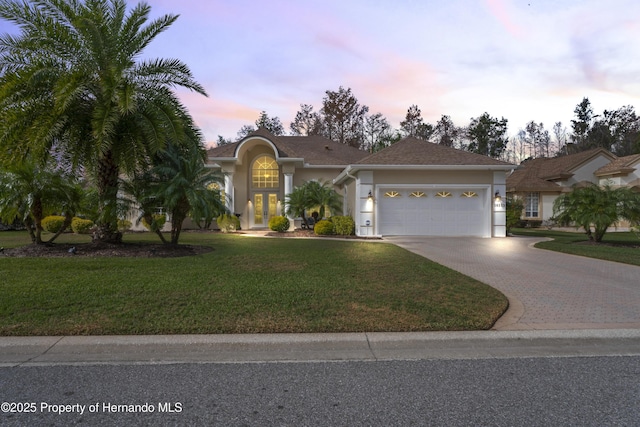 view of front facade featuring a lawn and a garage