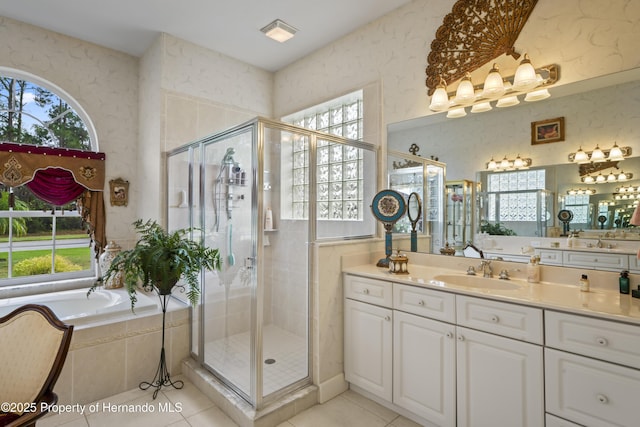 bathroom with shower with separate bathtub, vanity, tile patterned floors, and a wealth of natural light