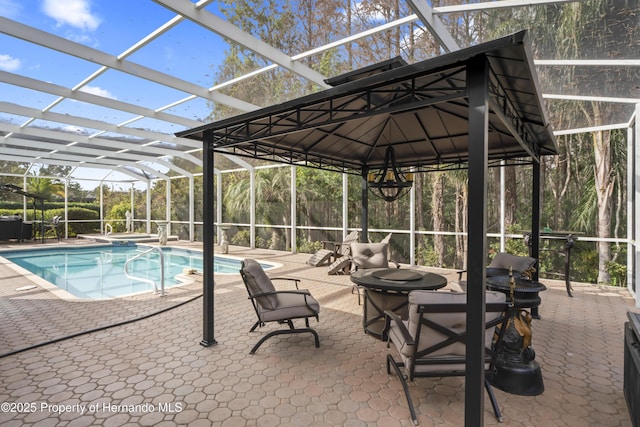 view of swimming pool featuring a patio and glass enclosure