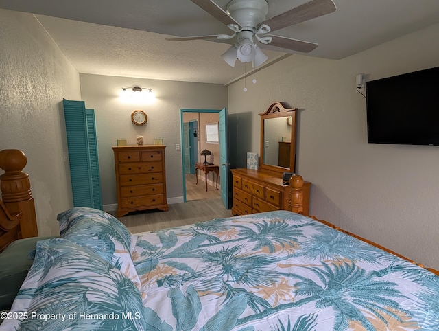 bedroom featuring ceiling fan, a textured ceiling, and light wood-type flooring