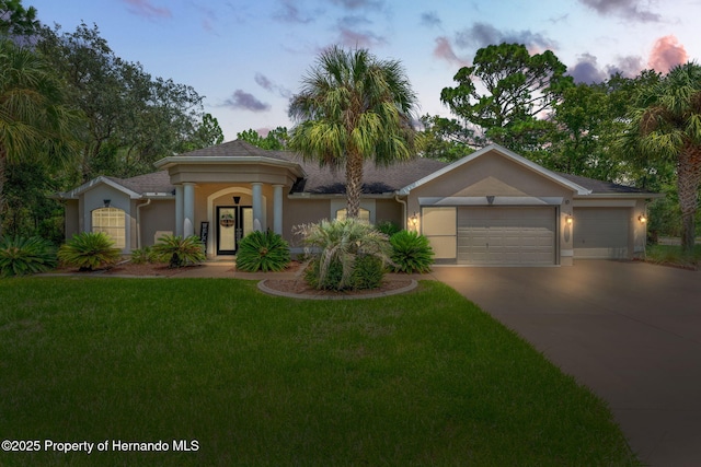 view of front of property with a garage and a yard