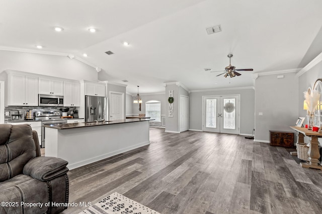 kitchen featuring lofted ceiling, ceiling fan, white cabinetry, a kitchen island with sink, and stainless steel appliances