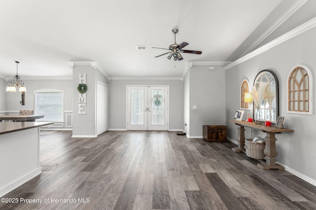 interior space featuring dark wood-type flooring, ceiling fan with notable chandelier, and crown molding