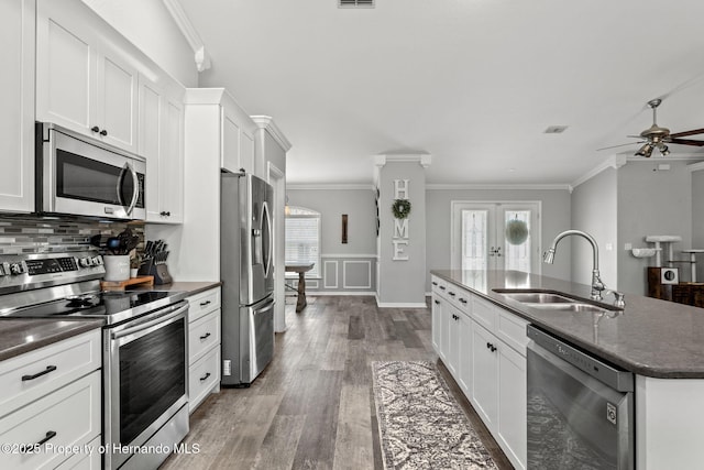 kitchen featuring stainless steel appliances, a kitchen island with sink, white cabinets, and sink