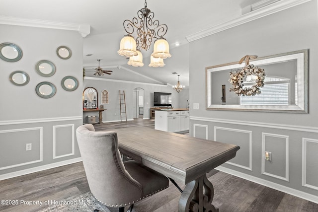 dining area with vaulted ceiling, dark hardwood / wood-style flooring, ceiling fan with notable chandelier, and crown molding