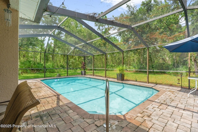 view of swimming pool featuring glass enclosure, a yard, and a patio