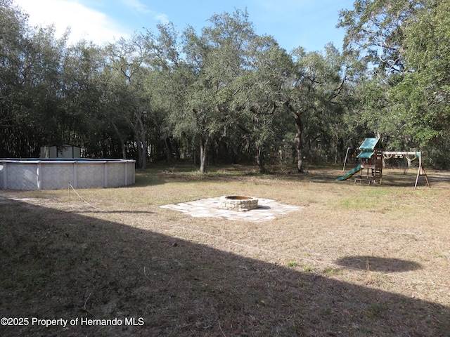 view of yard featuring a fire pit and a playground