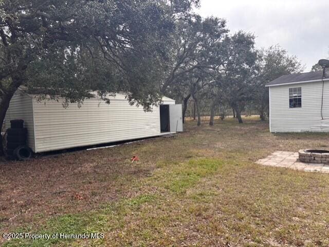 view of yard with an outbuilding and an outdoor fire pit