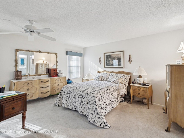 bedroom featuring light colored carpet, a textured ceiling, and ceiling fan