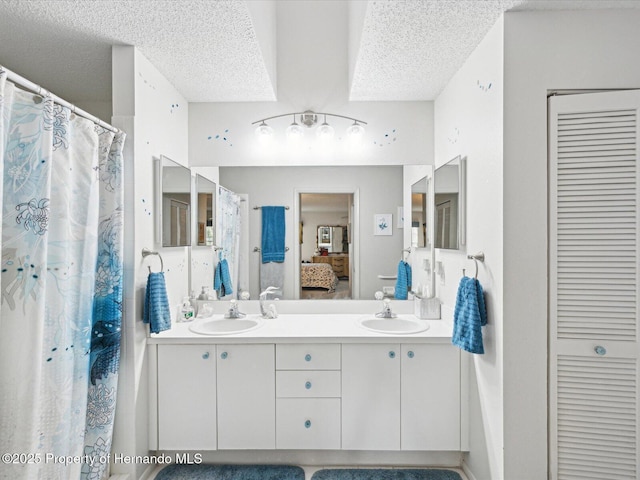 bathroom with vanity, a textured ceiling, and walk in shower