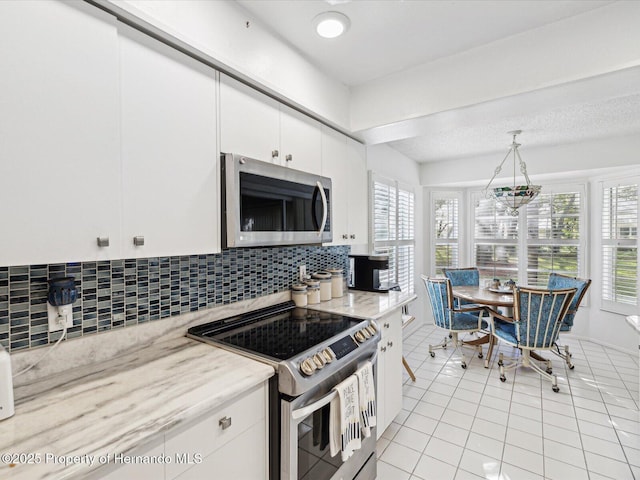 kitchen with white cabinetry, tasteful backsplash, pendant lighting, stainless steel appliances, and light stone countertops