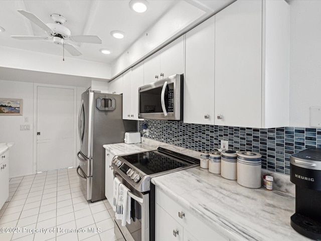 kitchen featuring appliances with stainless steel finishes, light tile patterned floors, white cabinets, and ceiling fan