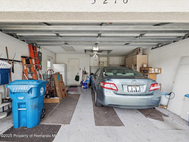 garage featuring white refrigerator and a garage door opener