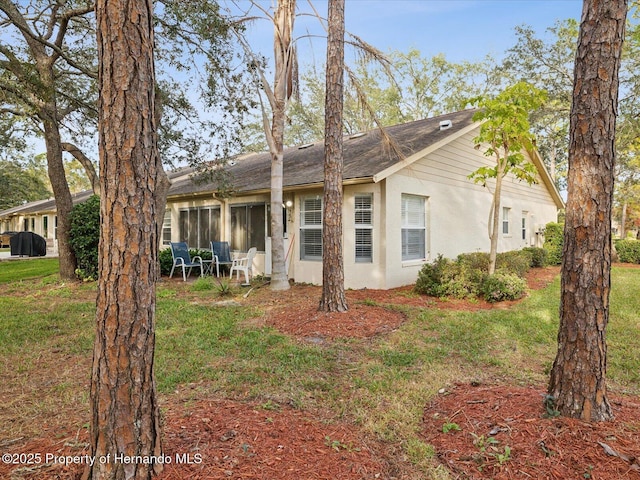 back of property featuring a lawn