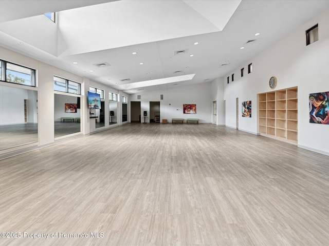 interior space with a high ceiling and light hardwood / wood-style flooring