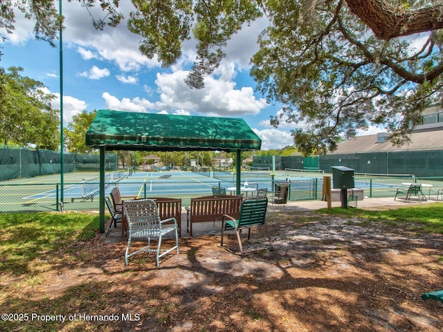 view of home's community featuring tennis court