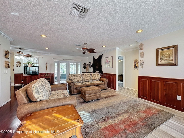 living room with crown molding, a textured ceiling, and hardwood / wood-style flooring